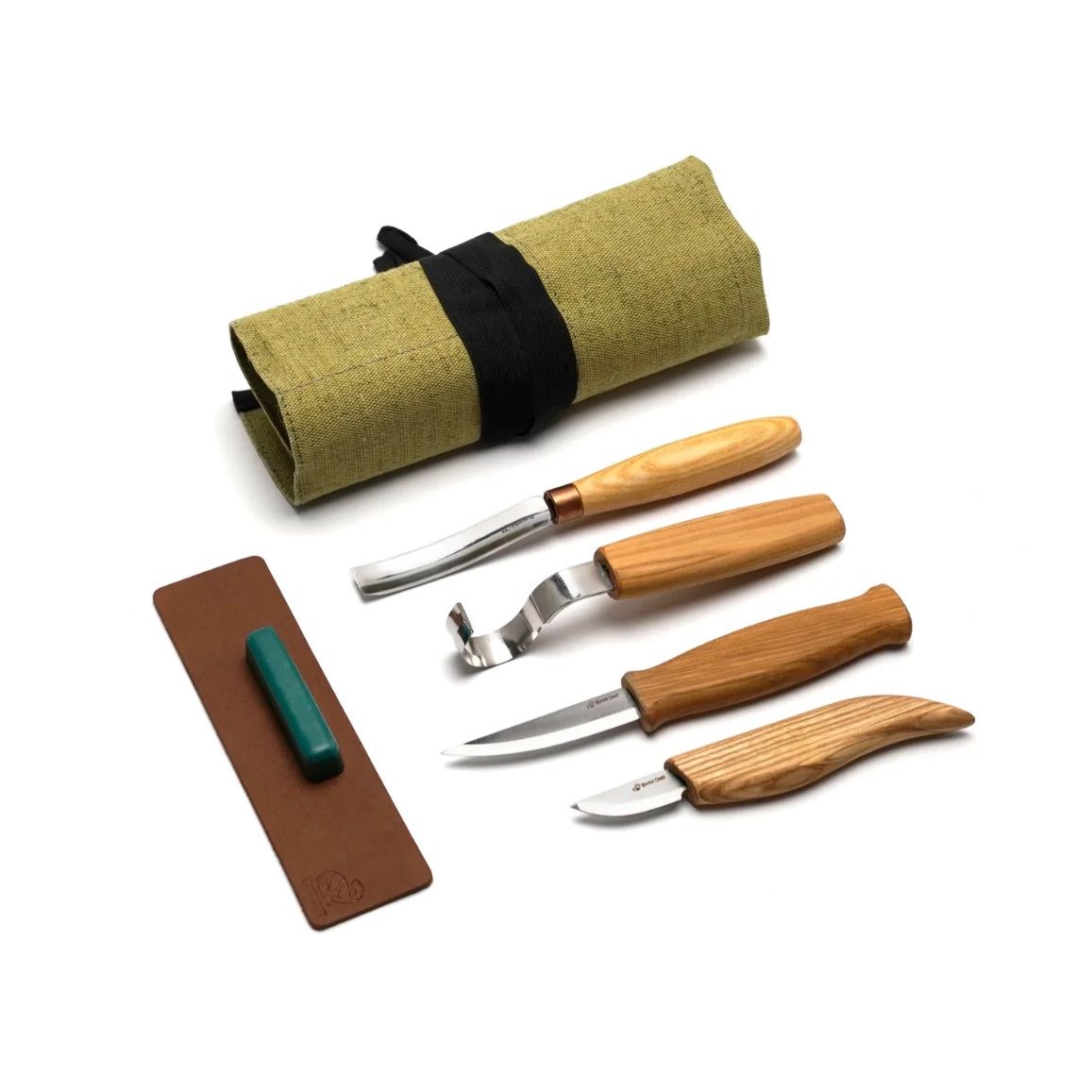 A collection of wood carving tools including a spoon carving knife, a whittling knife, a sloyd carving knife, and a compact short bent gouge, all with wooden handles and displayed with a green canvas roll.